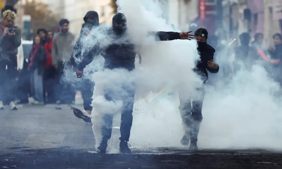 França reforçará policiamento em manifestações previstas para sábado Demonstrators react amid tear gas, the day after a national day of demonstrations against the cost of living and rising fuel prices, in Paris, France, October 18, 2026. REUTERS/Abdul Saboor