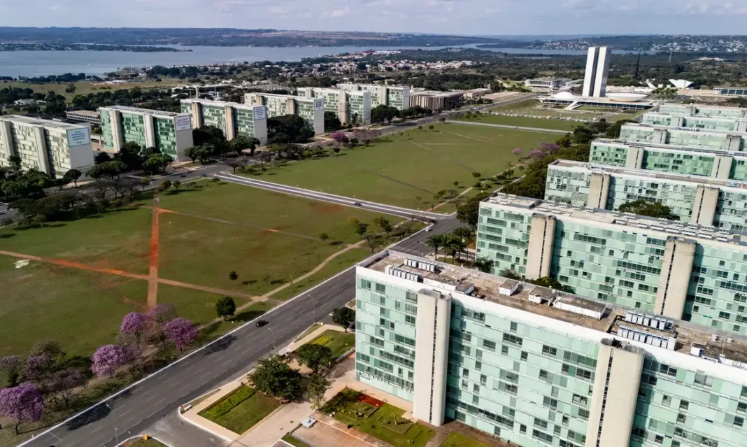 Entidades divulgam manifesto pela valorização do serviço público 22/06/2026 - Brasília - A floração dos ipês-roxos transforma a paisagem de Brasília em um espetáculo de cores que dura apenas algumas semanas, mas deixa marcas na memória durante todo o ano. Considerada uma das árvores mais simbólicas do Cerrado brasileiro, o ipê anuncia a chegada da estação seca justamente quando perde suas folhas e exibe flores em tons vibrantes que contrastam com o céu azul da Esplanada dos Ministérios. Em meio às linhas retas, ao concreto aparente e aos tons cinza característicos da arquitetura modernista idealizada por Oscar Niemeyer, os ipês surgem como protagonistas da paisagem urbana. A explosão de flores roxas quebra a monotonia das formas e colore avenidas, parques e áreas residenciais, criando uma das cenas mais marcantes da capital federal. Breve e intensa, a floração dos ipês lembra que alguns dos mais belos espetáculos da natureza são também os mais passageiros. Foto: Rafa Neddermeyer/Agência Brasil