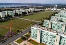 Entidades divulgam manifesto pela valorização do serviço público 22/06/2026 - Brasília - A floração dos ipês-roxos transforma a paisagem de Brasília em um espetáculo de cores que dura apenas algumas semanas, mas deixa marcas na memória durante todo o ano. Considerada uma das árvores mais simbólicas do Cerrado brasileiro, o ipê anuncia a chegada da estação seca justamente quando perde suas folhas e exibe flores em tons vibrantes que contrastam com o céu azul da Esplanada dos Ministérios. Em meio às linhas retas, ao concreto aparente e aos tons cinza característicos da arquitetura modernista idealizada por Oscar Niemeyer, os ipês surgem como protagonistas da paisagem urbana. A explosão de flores roxas quebra a monotonia das formas e colore avenidas, parques e áreas residenciais, criando uma das cenas mais marcantes da capital federal. Breve e intensa, a floração dos ipês lembra que alguns dos mais belos espetáculos da natureza são também os mais passageiros. Foto: Rafa Neddermeyer/Agência Brasil